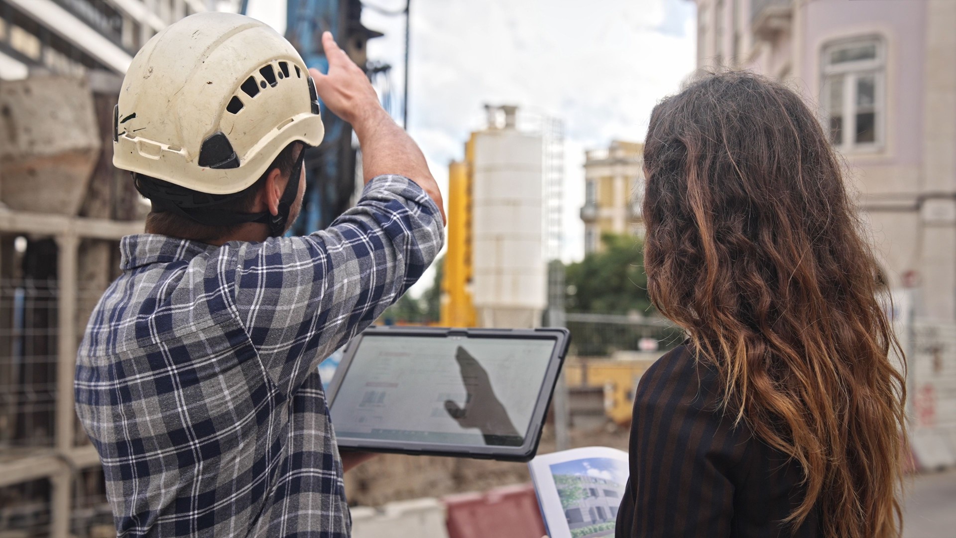 Engineer constructor discuss build plan. Man show construction site project.